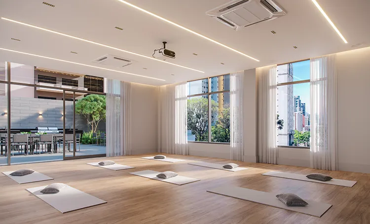 Sala de yoga com tapetes e janelas amplas