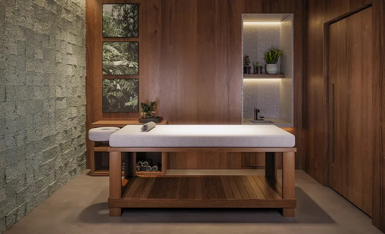 Sala de massagem com maca e revestimento em pedra e madeira