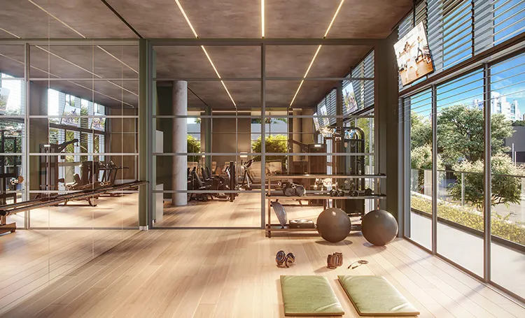 Sala multifuncional com equipamentos de ginástica e janelas amplas