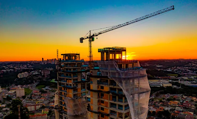 Obra de torre com guindaste ao pôr do sol em Curitiba