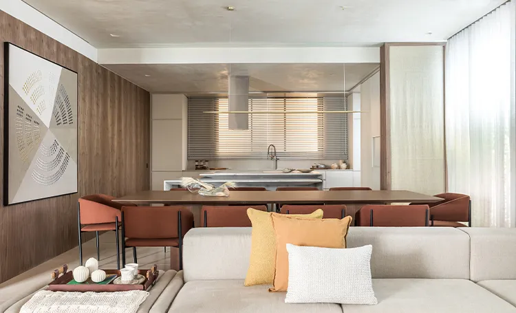 Sala com mesa de jantar, sofá claro e painel de madeira, no Trevi Batel