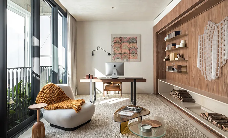 Home office com poltrona, mesa e estante com peça de macramê