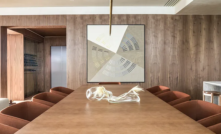 Mesa de jantar de madeira com escultura de vidro e quadro na parede