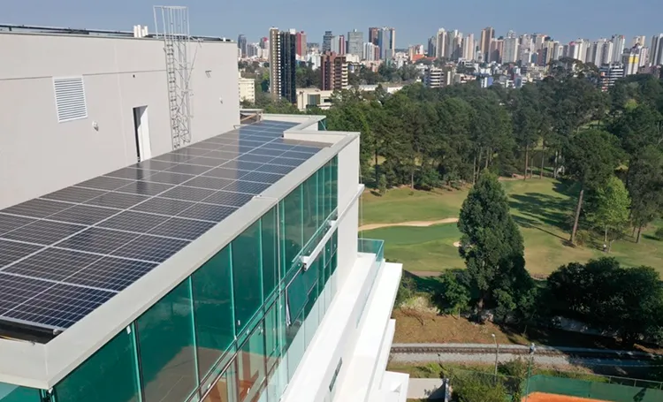 Painéis solares na cobertura de edifício com vista de Curitiba
