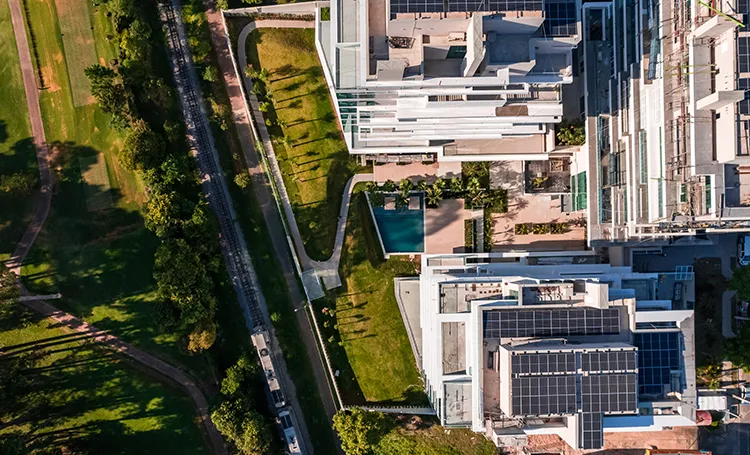 Vista aérea de edifícios com painéis solares e parque, em Curitiba
