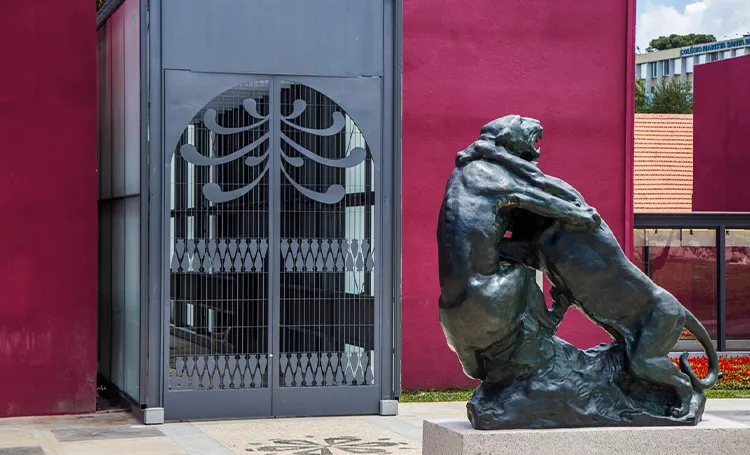 Portão metálico e escultura de felino em bronze no Museu Oscar Niemeyer