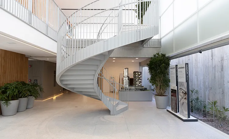 Hall da Galeria Laguna com escada em espiral branca e jardim interno