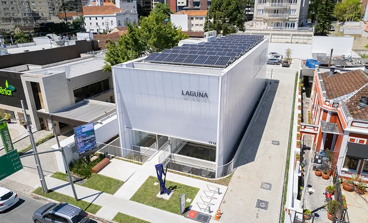 Vista aérea da Galeria Laguna, caixa branca translúcida com painéis solares no telhado