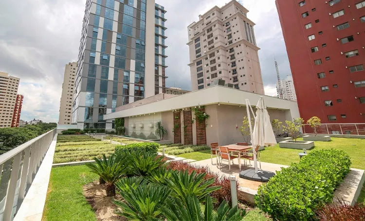 Terraço-jardim sobre prédio com torres de Curitiba ao fundo