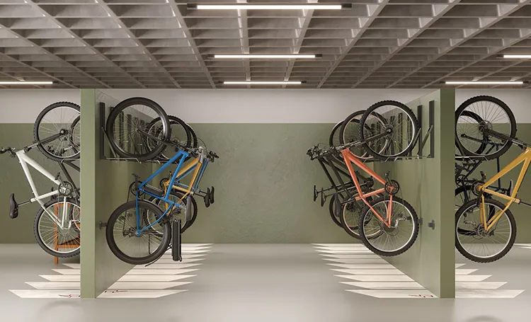 Bicicletário com bicicletas penduradas em suportes sobre parede verde