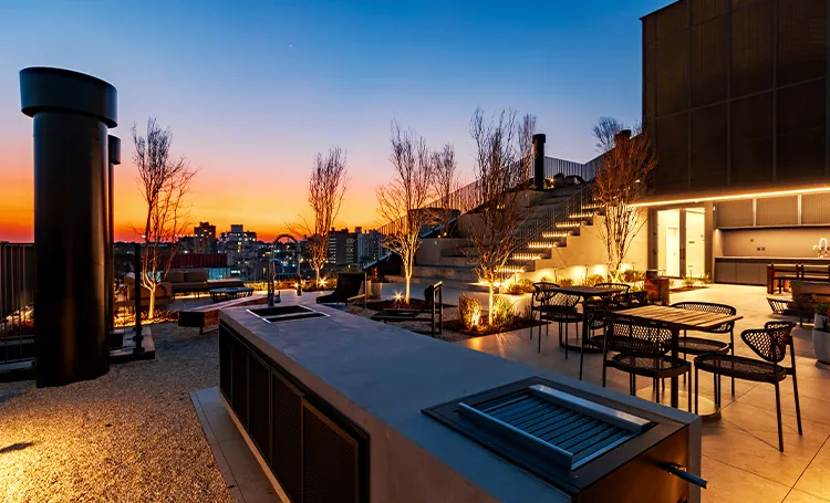 Terraço com churrasqueira e mesas ao entardecer, no VAZ Batel