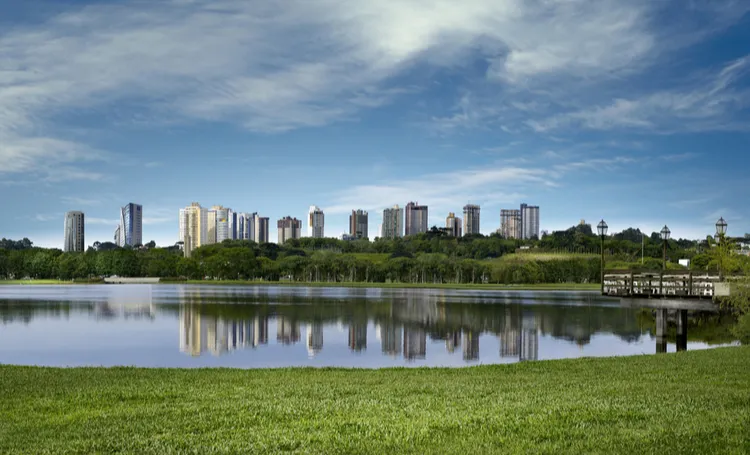 Lago de Curitiba com prédios ao fundo refletidos na água