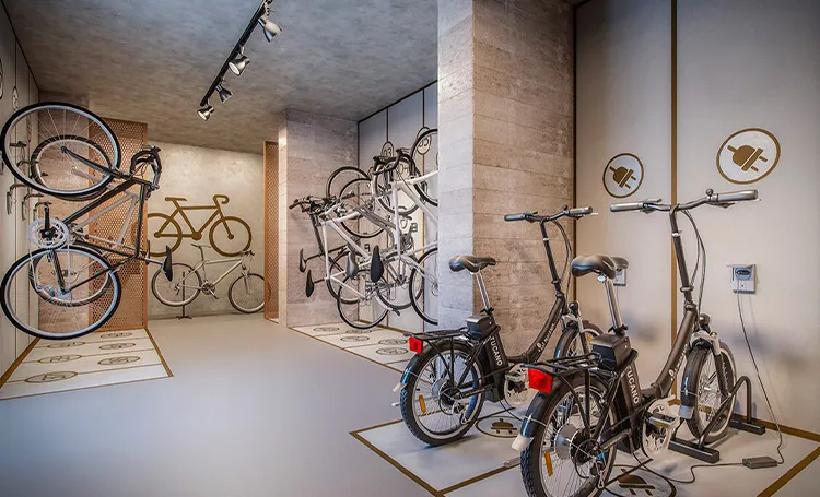 Bicicletário com bicicletas penduradas e duas bicicletas elétricas dobráveis, no PINAH