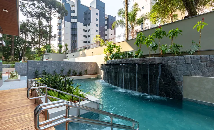 Piscina do PINAH com cascata de pedra e deck de madeira