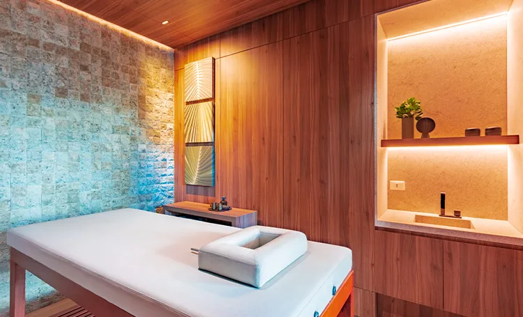 Sala de massagem com maca e nichos iluminados, no PINAH