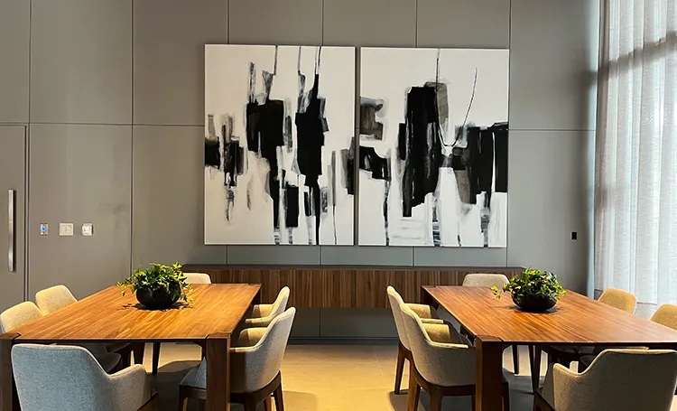 Quadro abstrato preto e branco sobre sala com mesas, no PINAH
