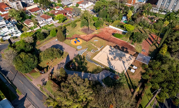 Vista aérea de praça com parquinho e áreas verdes em Curitiba