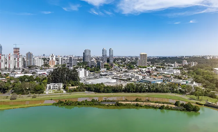 Região do Parque Barigui com lago e prédios ao fundo