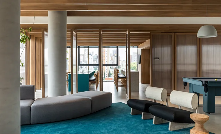 Clubhouse do VAZ Batel com sofás, mesa de sinuca e vista da cidade