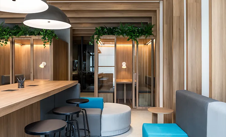 Coworking do VAZ Batel com bancada de madeira e banquetas