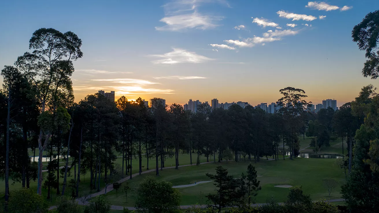 Vista do campo de golfe ao entardecer com a cidade ao fundo, ALMÁA Cabral