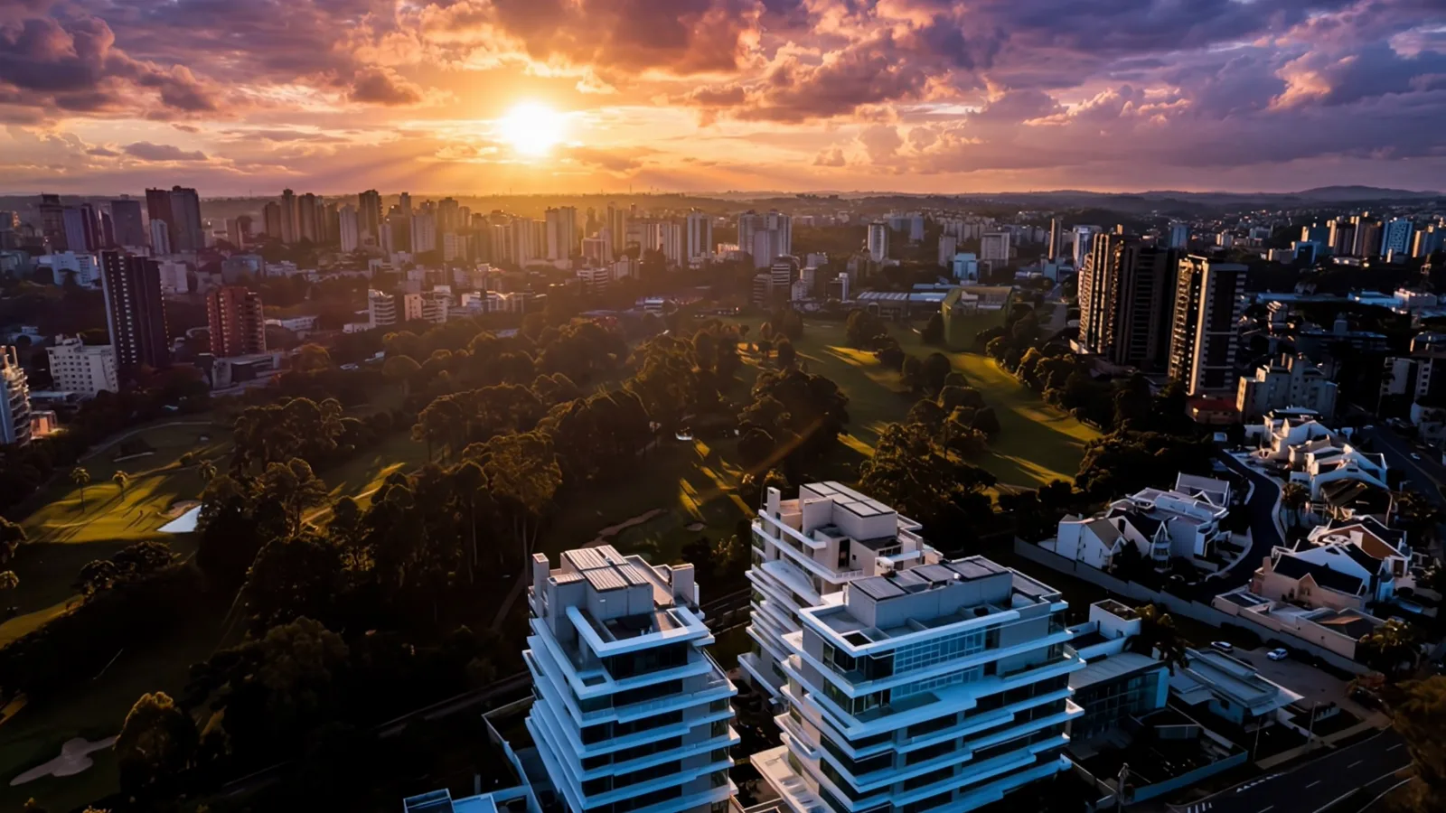 Vista aérea ao pôr do sol com os dois blocos e o parque, ALMÁA Cabral
