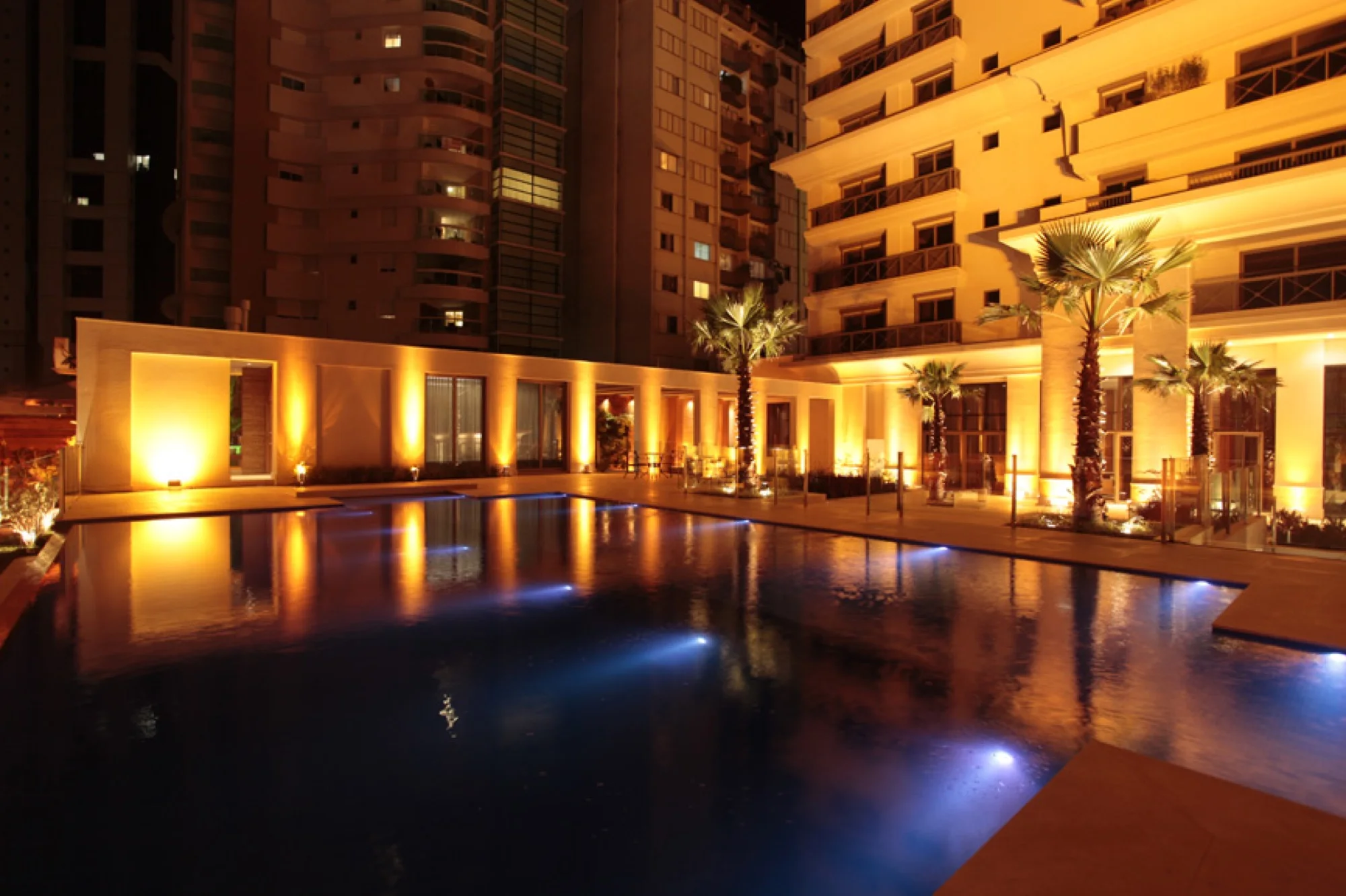 Piscina do Éden à noite, com fachada iluminada ao redor