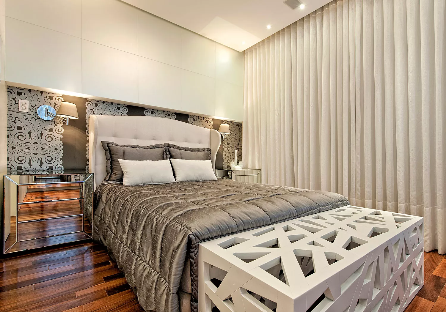 Suíte com cama estofada e cortinas no EOS Barigui