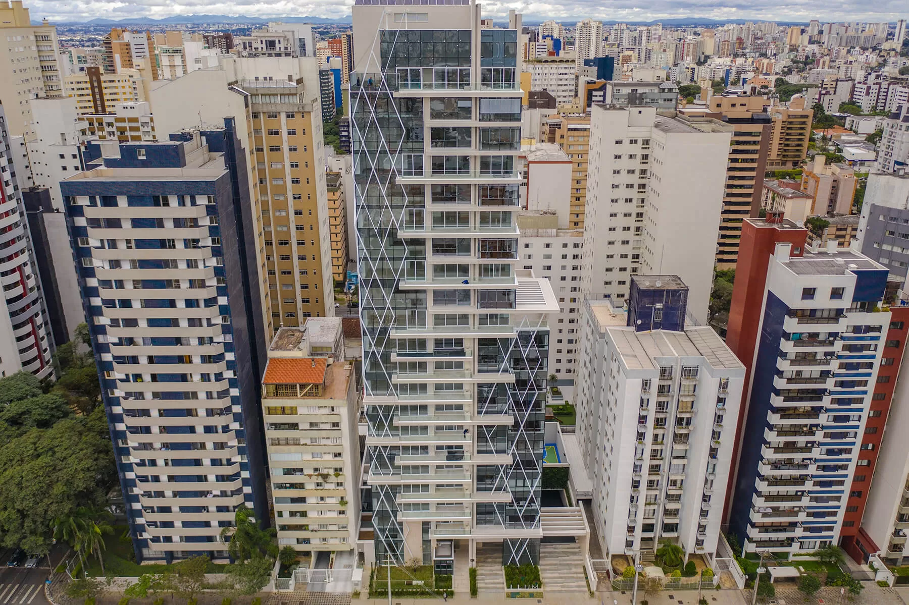 Vista aérea do edifício entre prédios do bairro, LLUM Batel