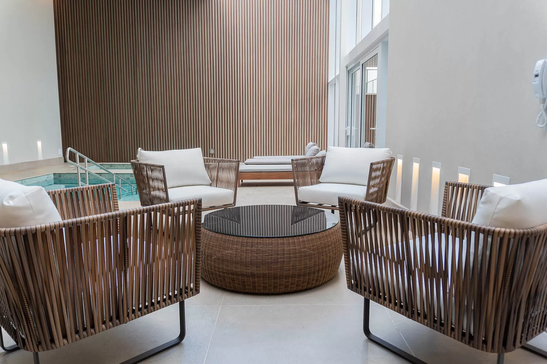 Área de descanso com poltronas trançadas ao lado do spa, LLUM Batel