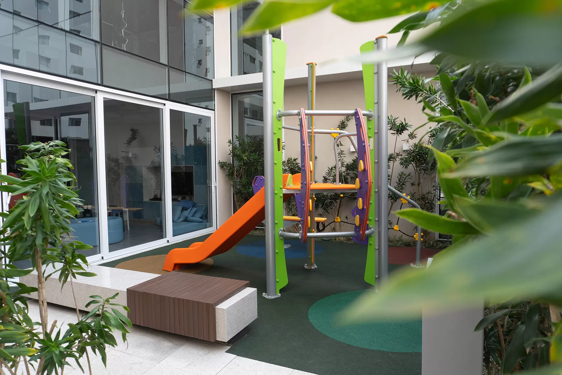 Playground interno com escorregador e plantas, LLUM Batel