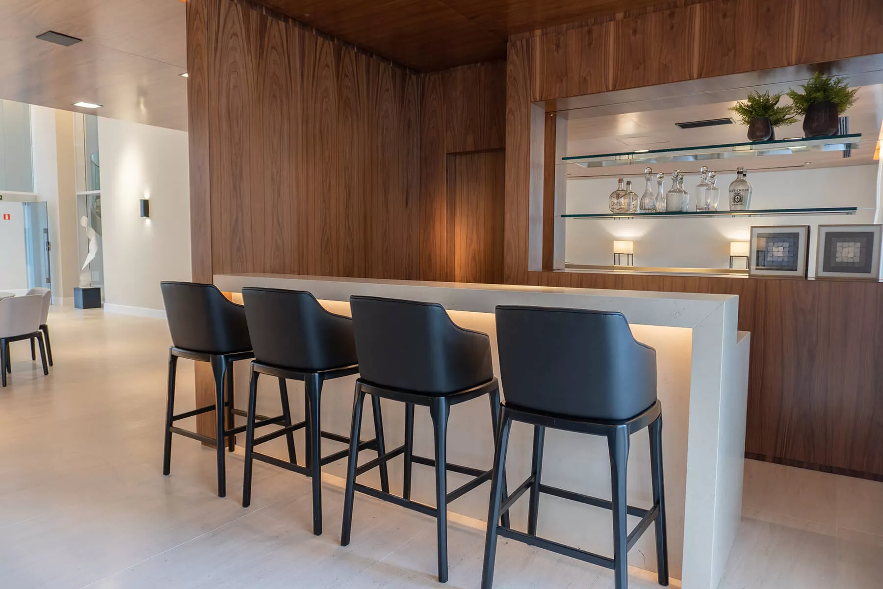 Bar com bancos altos e painel de madeira, LLUM Batel