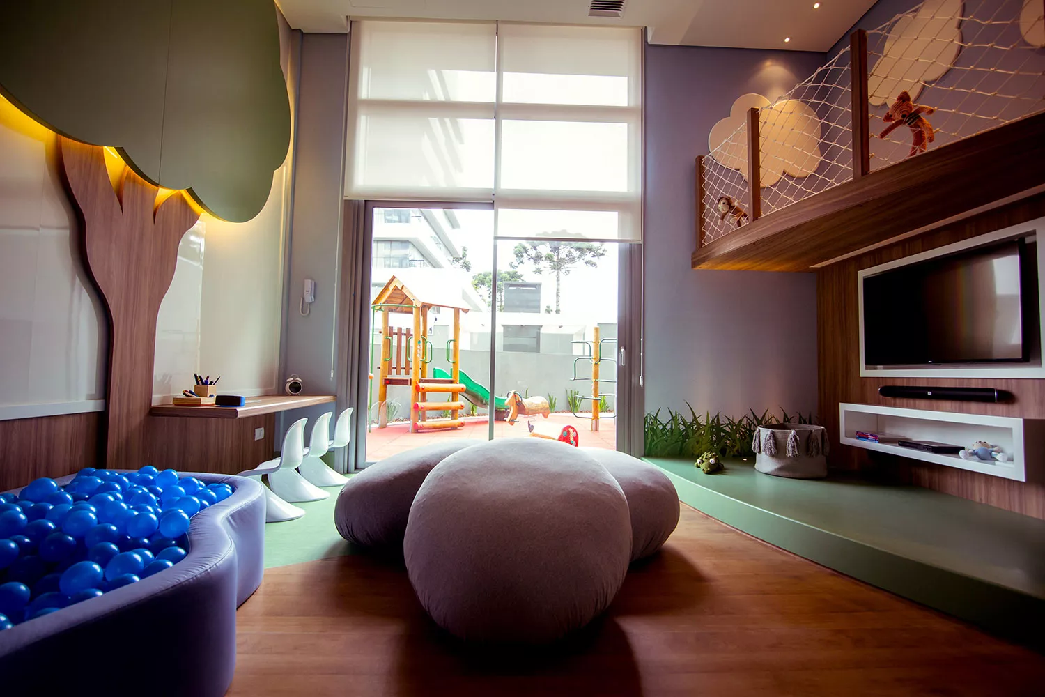 Brinquedoteca com árvore, piscina de bolinhas e vista do play no MAI Home