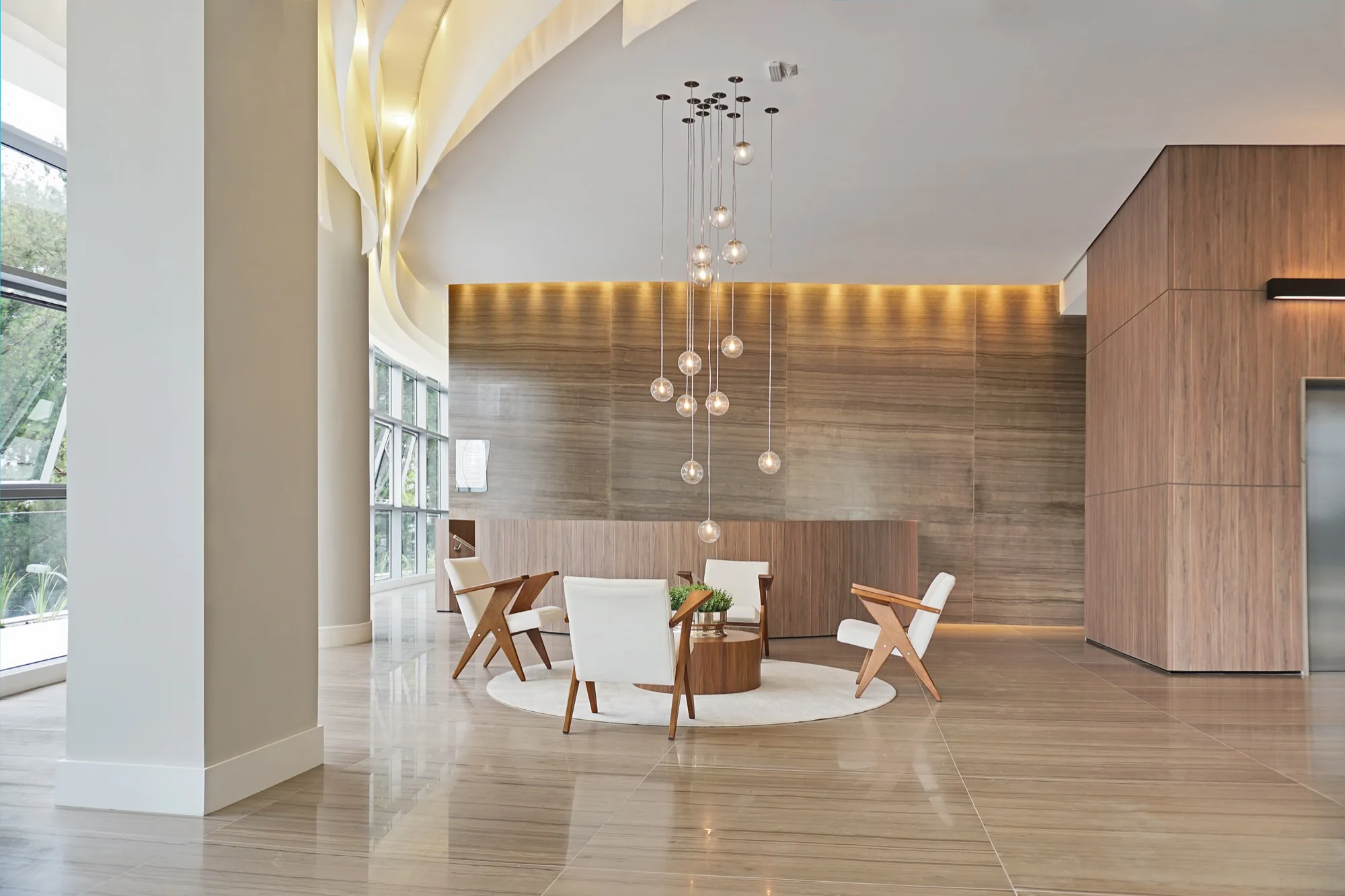 Hall com poltronas e lustre pendente no MAI Home