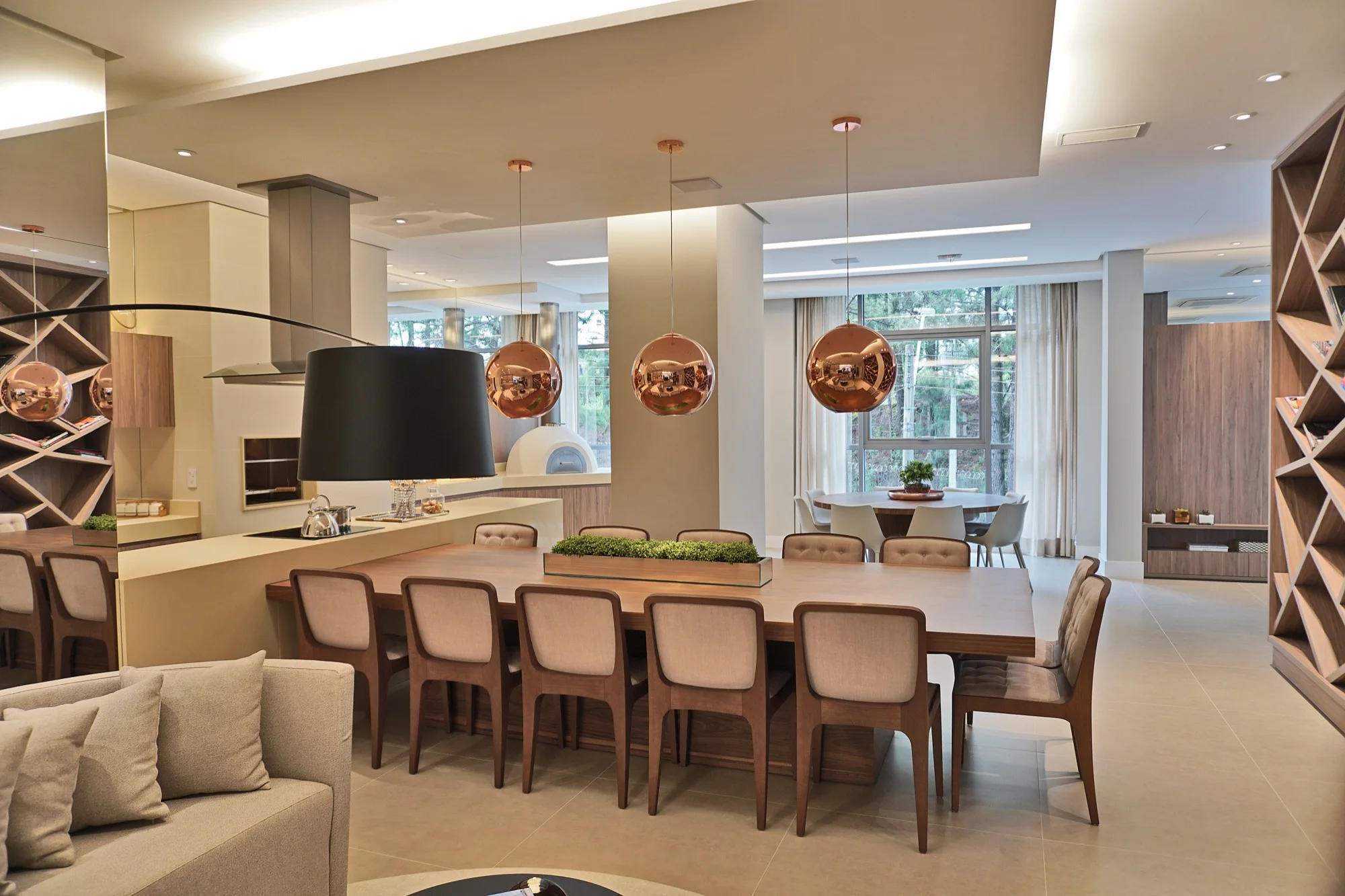 Salão com mesa de jantar e luminárias de cobre no MAI Home