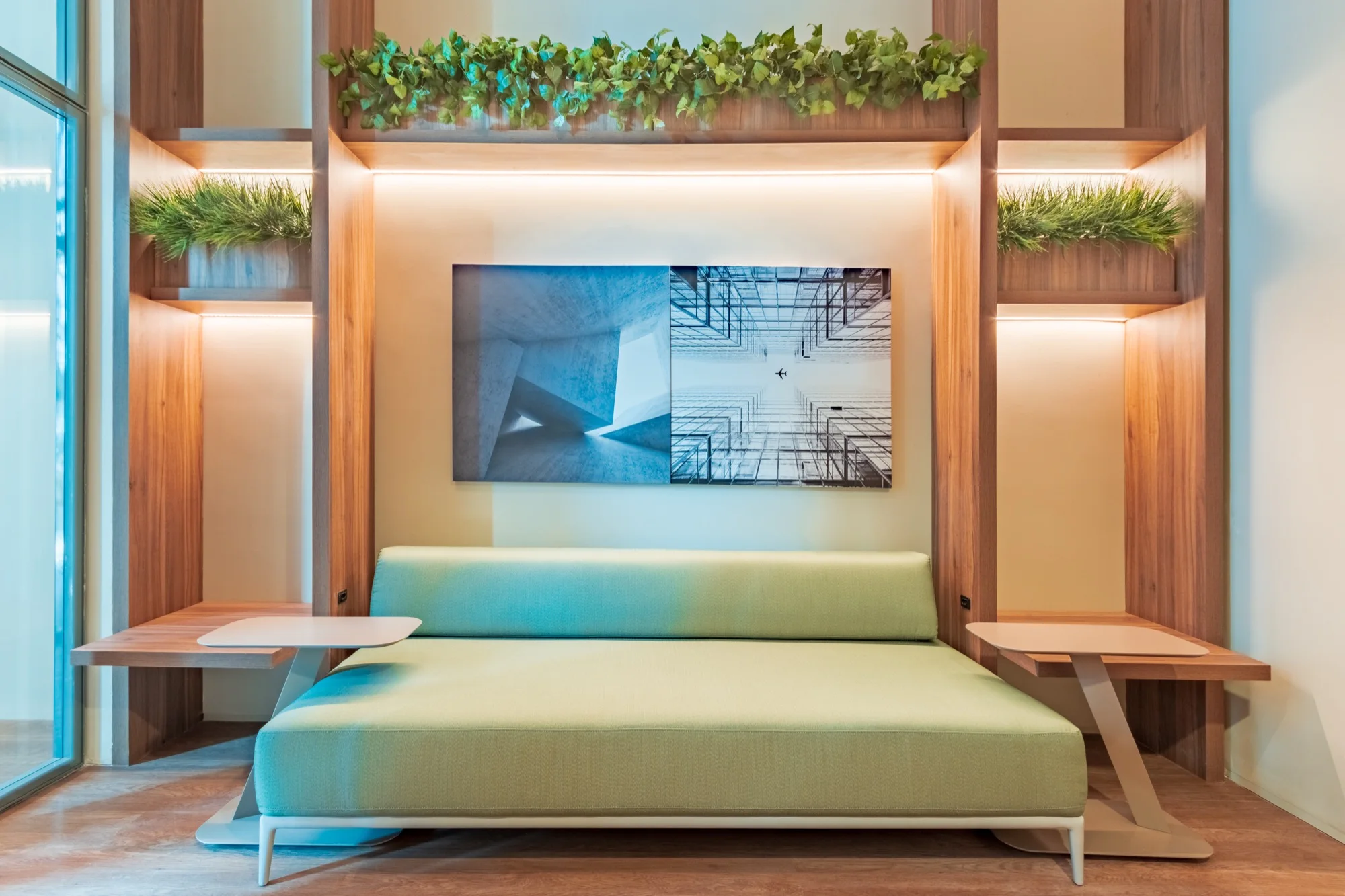 Sala de estar com sofá verde e painel de madeira no PINAH