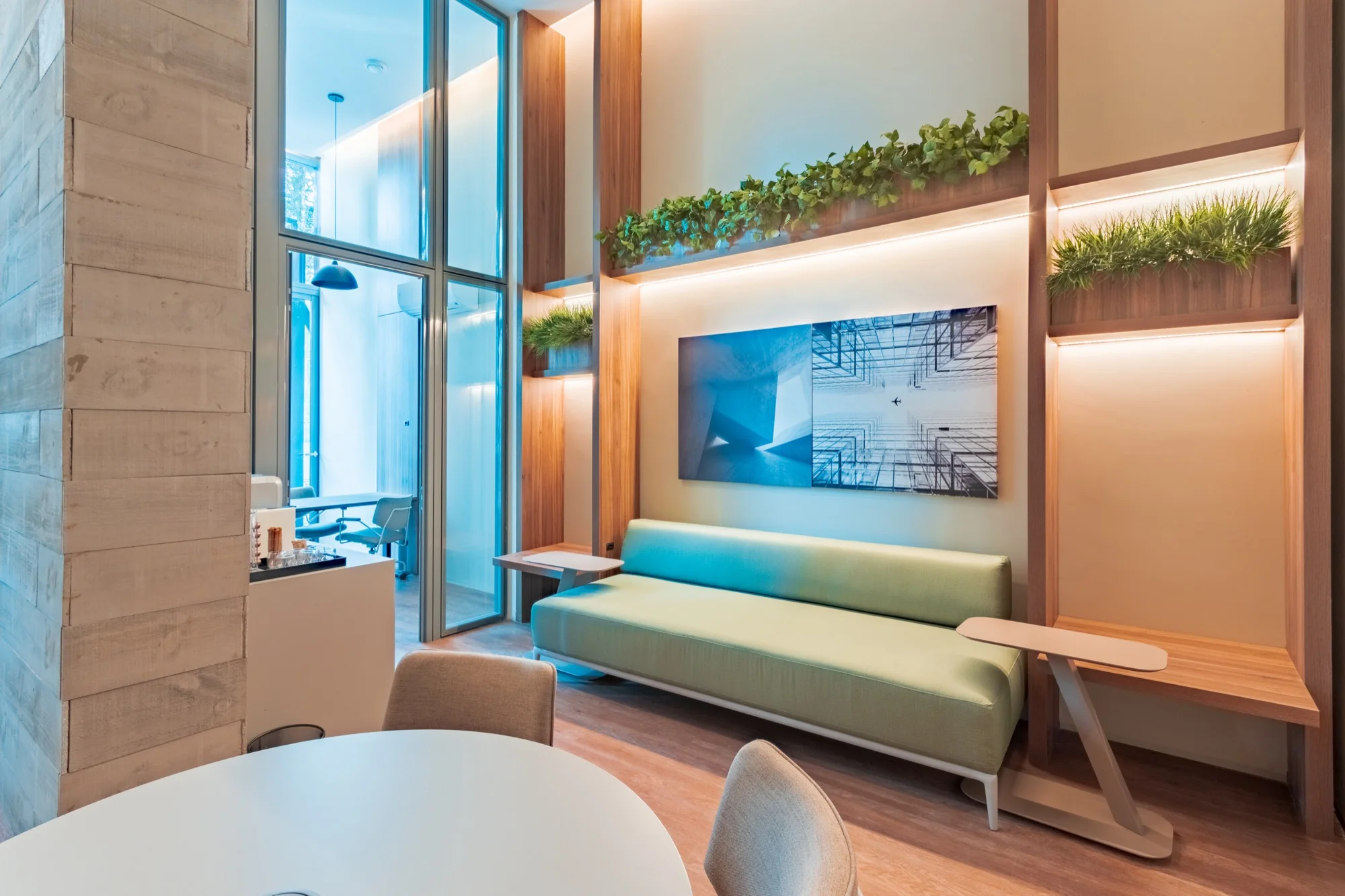 Sala de estar com sofá, painel de madeira e plantas no PINAH