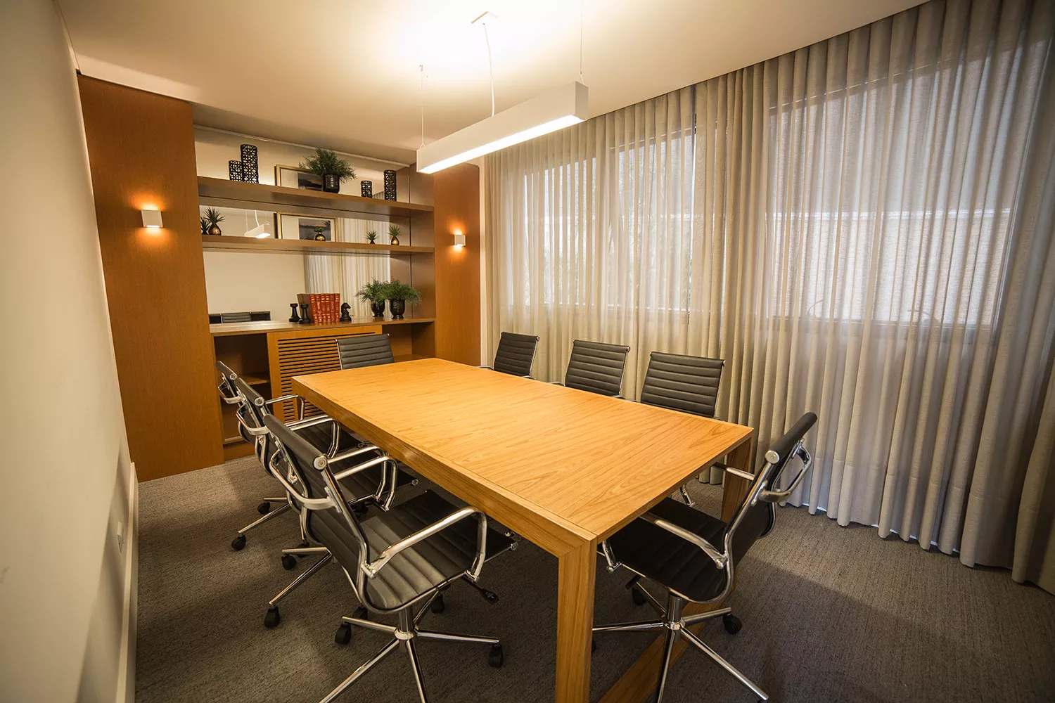 Sala de reuniões do Soul Batel Soho com mesa de madeira