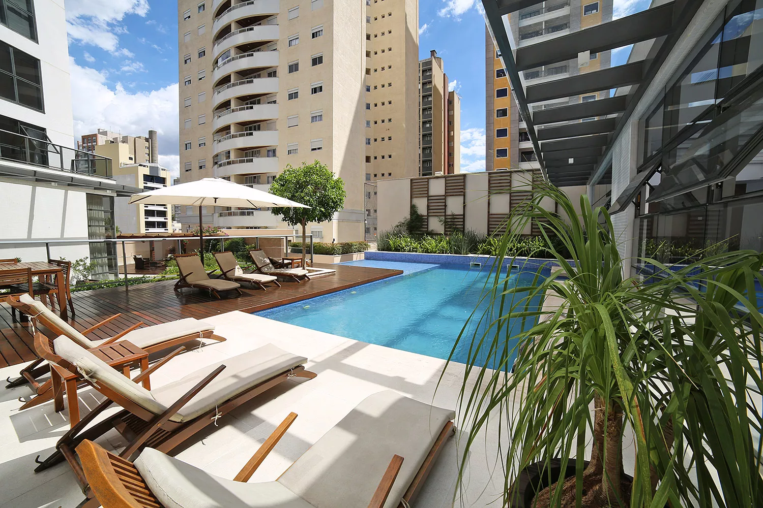 Piscina e deck do Soul Batel Soho com edifícios ao fundo