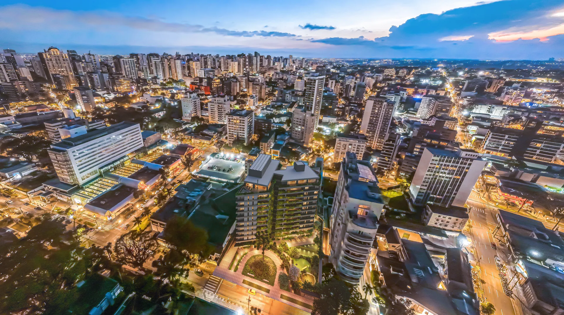 Vista aérea de Curitiba ao anoitecer com o entorno do ZAHI Taunay